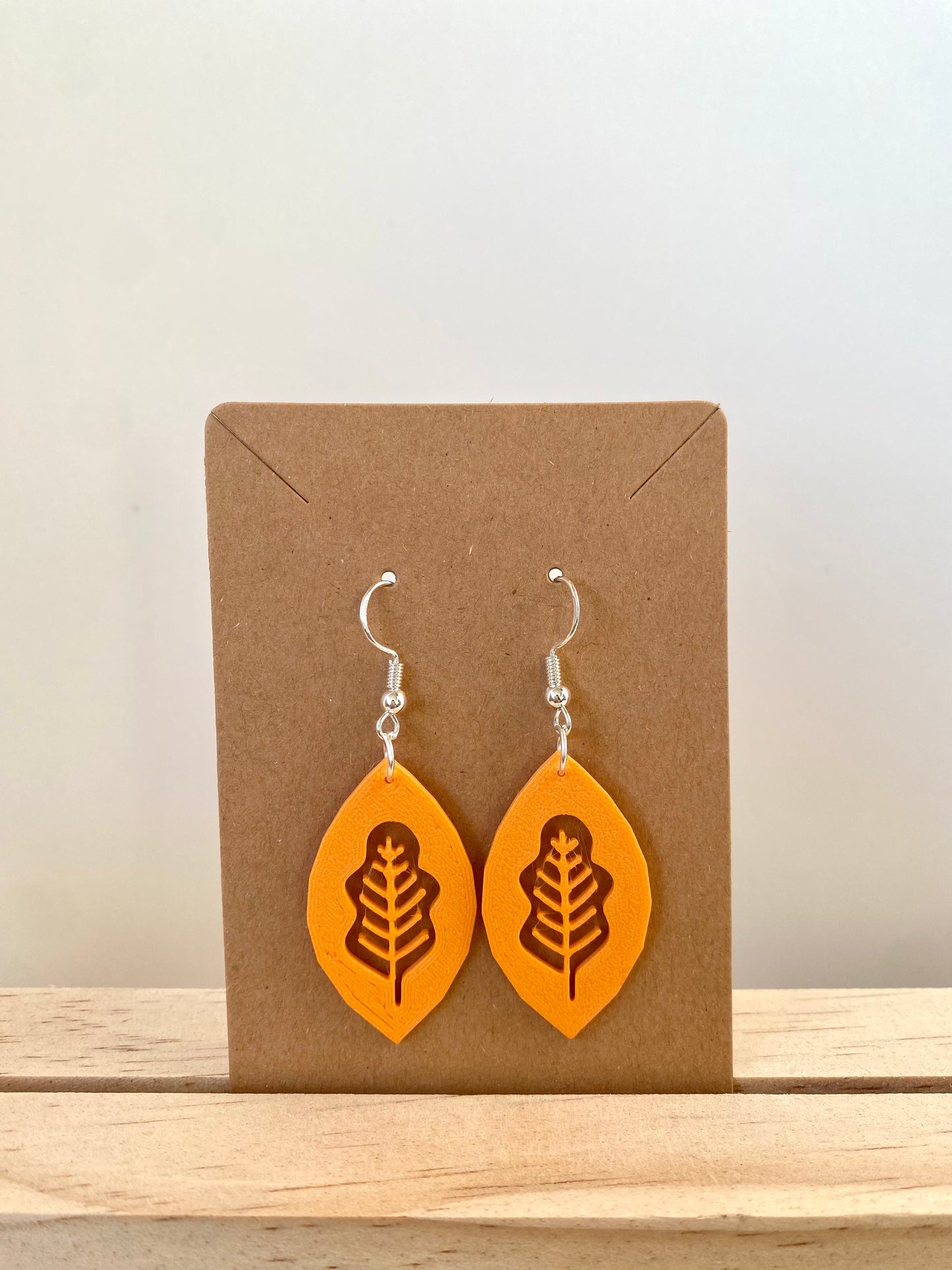 White Oak Leaf Ellipse Earrings in orange.